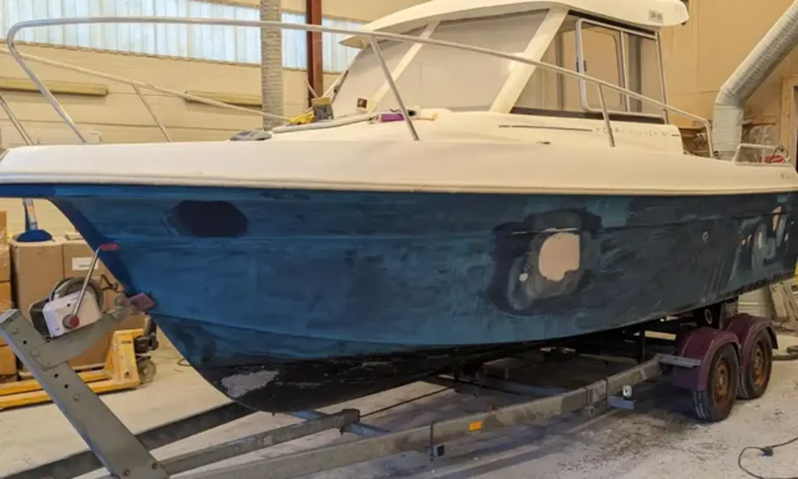 Båt med skrog under reparasjon hos FiberGlass